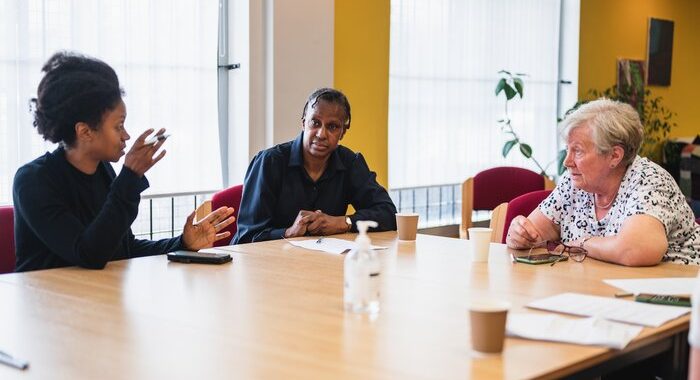 Three women at work sitting round a table having a conversation