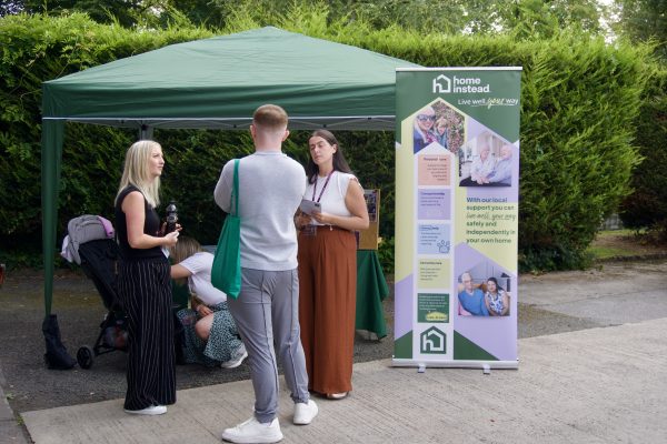 Three people outside a gazebo talking